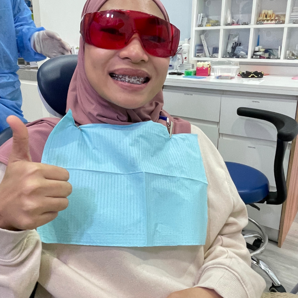 Happy braces patient at Alam Dental Hutan Melintang Teluk Intan with her dentist after dental treatment