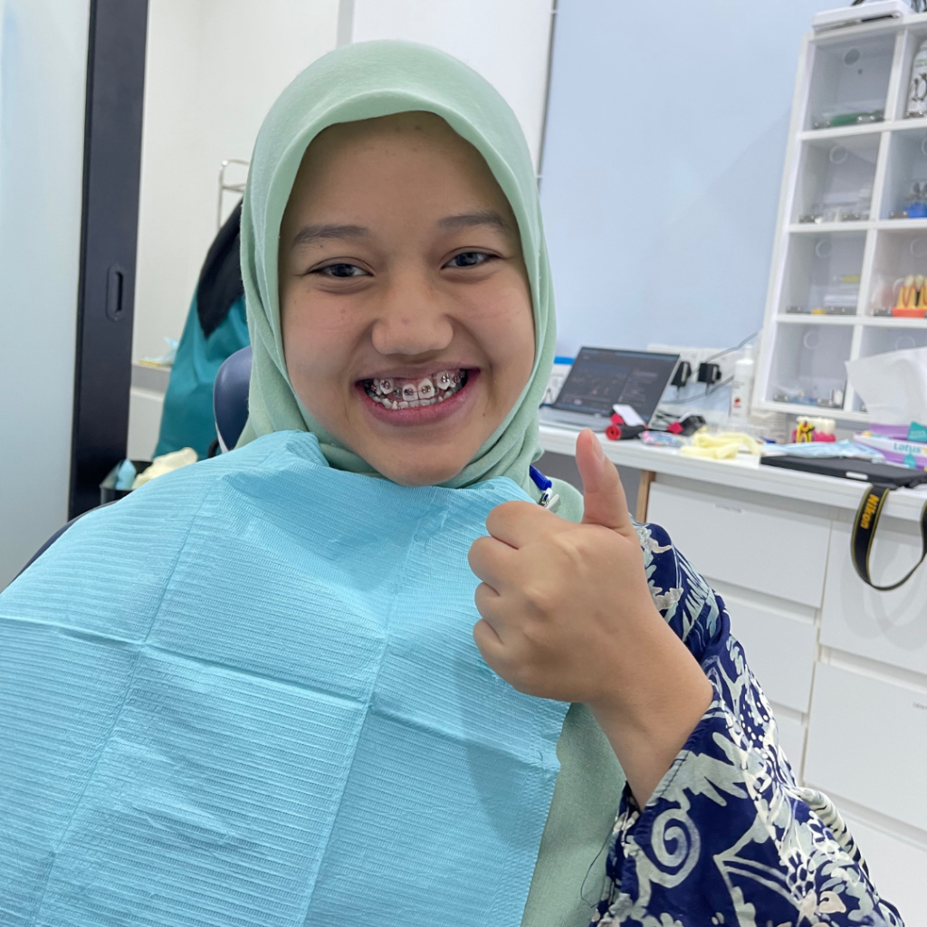 Happy braces patient at Alam Dental Hutan Melintang Teluk Intan with her dentist after dental treatment