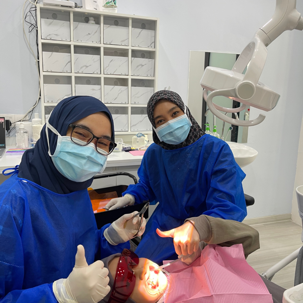 Happy braces patient at Alam Dental Hutan Melintang Teluk Intan with her dentist after dental treatment